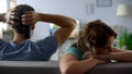 Offended girl sitting by boyfriend watching football match tv, relations crisis Royalty Free Stock Photo