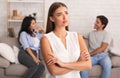 Offended Girl Standing While Boyfriend Flirting With Girl Sitting Indoor Royalty Free Stock Photo