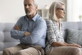 Offended husband and mad wife sitting with back touch Royalty Free Stock Photo