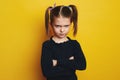 Sad girl with crossing arms standing isolated over yellow studio background Royalty Free Stock Photo