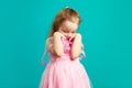 Offended little girl in pink dress on blue . Royalty Free Stock Photo