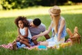 Offended little girl sitting with parents on picnic Royalty Free Stock Photo