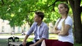 Offended teen couple sitting in park on bench, ignoring each other, conflict Royalty Free Stock Photo