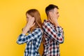 Offended young couple, man and woman standing back to each other, couple in quarrel on white background Royalty Free Stock Photo