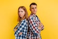 Offended young couple, man and woman standing back to each other, couple in quarrel on white background Royalty Free Stock Photo