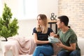 Offended young woman refusing to take gift from her boyfriend at home