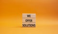 We offer solutions symbol. Concept words We offer solutions on wooden blocks. Beautiful orange background. Business and We offer Royalty Free Stock Photo