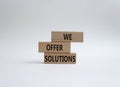We offer solutions symbol. Concept words We offer solutions on wooden blocks. Beautiful white background. Business and We offer Royalty Free Stock Photo