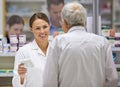 Offering friendly advice to clients. a young pharmacist helping an elderly customer. Royalty Free Stock Photo