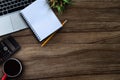 Office accessories laptop, calculator, notepad, and coffee cup on a wooden table background. Royalty Free Stock Photo