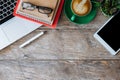 Top view. Office accessories laptop, smartphone, notepad, and coffee cup on a wooden table background. Royalty Free Stock Photo