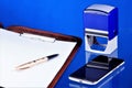 Office accounting desktop, blue background, with the necessary accessories. Folder with documents, smartphone Communicator for Royalty Free Stock Photo