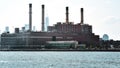 Office, apartments and industrial chimneys buildings in the skyline at sunset, from Hudson river. Pollution and industry concept.