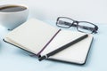 Office blue table with blank notepad, pencil, glasses and coffee cup. Copy space for text. Royalty Free Stock Photo