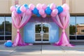 office building entrance draped with a banner and surrounded by balloons