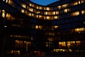 Office building exterior with glowing lights in windows at night city Royalty Free Stock Photo