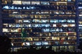 Office building exterior in the late evening with interior lights. Business people working in the evening. Illuminated office Royalty Free Stock Photo