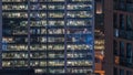 Office building exterior during late evening with interior lights on and people working inside night timelapse Royalty Free Stock Photo