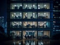 office building exterior looking through window business person meeting working late at night in meeting room