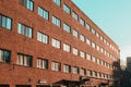 Office building in loft style with walls made of red brick. Facade of commercial office with windows