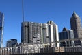 An office building under construction with workers and sliding platforms along the building surrounded by other glass skyscrapers Royalty Free Stock Photo