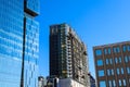 An office building under construction with workers and sliding platforms along the building surrounded by other glass skyscrapers Royalty Free Stock Photo