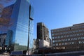 An office building under construction with workers and sliding platforms along the building surrounded by other glass skyscrapers Royalty Free Stock Photo