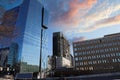 An office building under construction with workers and sliding platforms along the building surrounded by other glass skyscrapers Royalty Free Stock Photo