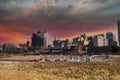 Office buildings and skyscrapers in the cityscape along Wolf Creek Harbor with bare winter trees and yellow winter grass Royalty Free Stock Photo