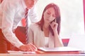 Businesswoman concentrating while colleague explaining at desk