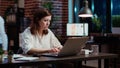 Office clerk looking through financial business documents on laptop