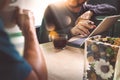 Office coffee break with two designer colleagues sitting chatting over cups of coffee,flower vase,digital tablet docking smart Royalty Free Stock Photo