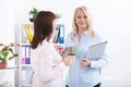 Office coffee break. Two female colleagues with cups of coffee talking. Royalty Free Stock Photo