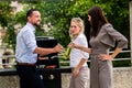 Office colleagues grilling sausages at bbq after work Royalty Free Stock Photo