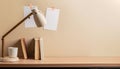 Office desk with books, lamp and coffee cup on beige wall background AI generated