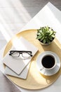 Office desk with coffee cup, succulent plant, eyeglasses and notepad. Minimal style image of business table Royalty Free Stock Photo