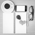 office desk : coffee and phone with car key,eyeglasses,notepad,heart black and white color Royalty Free Stock Photo