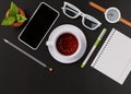 Office desk with a cup of tea, smartphone, wristwatch, notebook, pencil, glasses, potted plant. View from above. Template for Royalty Free Stock Photo