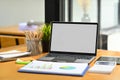 Office desk with laptop, financial chart, calculator and pencil holder. Empty screen for your advertising text message