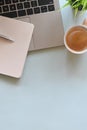 Office desk of laptop including coffee cup, pencil, notebook and potted plant. Royalty Free Stock Photo