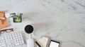 Office desk marble table with computer keyboard, notebook paper, pen and coffee cup. Royalty Free Stock Photo