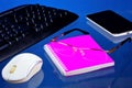 Office Desk with necessary accessories, blue background. On the desktop office notebook for important records, smartphone