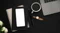 Office desk with office supplies and smartphone mockup on black background Royalty Free Stock Photo