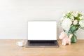 Office desk table with laptop computer with blank screen mockup, supplies, cup of coffee, flowers bouquet, unicorn on wooden Royalty Free Stock Photo