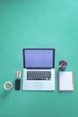 Office desk table with laptop, smart phone, cup of coffee and supplies, isolated on green background,flat lay Royalty Free Stock Photo