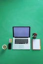 Office desk table with laptop, smart phone, cup of coffee and supplies, isolated on green background,flat lay Royalty Free Stock Photo