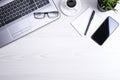 Office desk table with laptop, smart phone, cup of coffee and supplies, on wooden background. Top view with copy space, flat lay Royalty Free Stock Photo