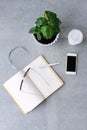 Office desk table with notebook planner, smart phone, glasses, coffee tree and coffee cup. Top view with copy space. Royalty Free Stock Photo