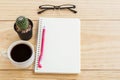 Office desk table with notebooks,glasses, pen and a cactus with cup of coffee Royalty Free Stock Photo