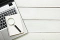 Office desk table with supplies. Top view. Copy space for text. Laptop, blank notepad, and magnifying glass Royalty Free Stock Photo